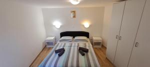 małą sypialnię z łóżkiem i kapciami w obiekcie Holiday Houses Marta w Rovinj
