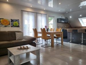 ein Wohnzimmer mit einem Sofa und einem Tisch sowie eine Küche in der Unterkunft Ferienwohnung Sabine in Annweiler am Trifels