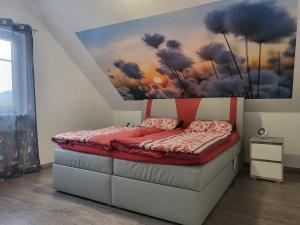 a bedroom with a bed with a painting on the wall at Ferienwohnung Sabine in Annweiler am Trifels