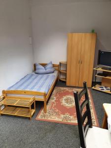 SiebenlehnにあるMonteurzimmer Fuchs-Kupkeのベッドルーム1室(ベッド1台付)、木製キャビネットが備わります。