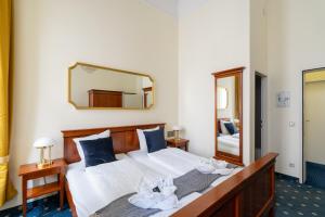 1 dormitorio con 1 cama con sábanas blancas y espejo en Hotel-Zimmer direkt am See, en Gmunden