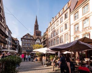 uma rua da cidade com edifícios e pessoas sentadas a mesas em Hyper-centre : Vue Cathédrale, prox. Petite France em Estrasburgo