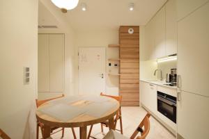 a kitchen with a table and chairs in a room at RentPlanet - Apartamenty Shellter in Rogowo