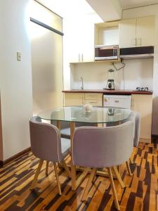 a kitchen with a glass table and two chairs at Villa Salluzzi Apart Hotel in Tacna
