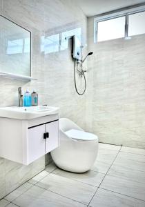 a white bathroom with a sink and a shower at ALVILLA - Jalan Sultan Ismail in Kuala Terengganu