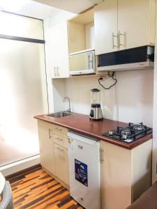 a small kitchen with a stove and a sink at Villa Salluzzi Apart Hotel in Tacna