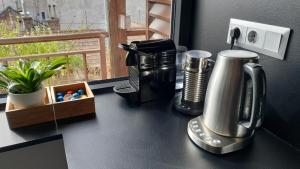 a counter top with a coffee maker on a table at Modern top floor loft with balcony in Budapest