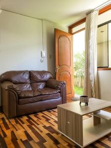 een woonkamer met een bruine leren bank en een salontafel bij Villa Salluzzi Apart Hotel in Tacna