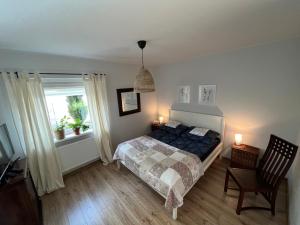 ein Schlafzimmer mit einem Bett, einem Stuhl und einem Fenster in der Unterkunft Apartament Stanowisko in Gliwice