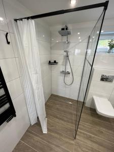 ein Bad mit einer Dusche und einem Waschbecken in der Unterkunft Apartament Stanowisko in Gliwice