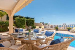 d'une terrasse avec une table et des chaises à côté de la piscine. dans l'établissement Villa Vista Gomera, à Puerto de Santiago