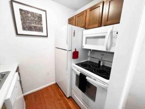 a kitchen with a stove and a white refrigerator at Top (third) floor loft condo. Full resort access. in Claysburg