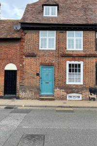 um edifício de tijolos com uma porta azul numa rua em Entire 3 bedroom Grade 2 listed, close to town centre em Kent