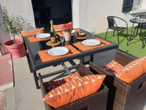 uma mesa e cadeiras com pratos e uma garrafa de vinho em joli appartement classé 4 étoiles em Saint-Georges-dʼOléron