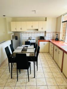 eine Küche mit einem Tisch und Stühlen im Zimmer in der Unterkunft Villa Salluzzi Apart Hotel in Tacna