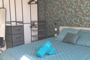 um bicho de peluche azul sentado em cima de uma cama em joli appartement classé 4 étoiles em Saint-Georges-dʼOléron