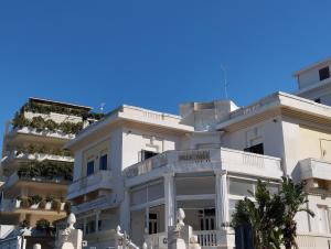 un edificio bianco con statue davanti di Casa Mistral a Bari