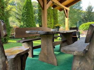 a picnic table and two benches under a pavilion at Kajta-Völgye Guesthouse, Jósvafő, National Park Aggtelek in Jósvafő