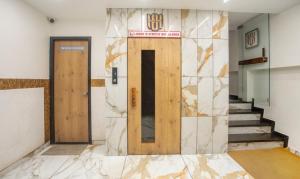 a lobby with two doors and a marble wall at Treebo Trend Urban in Surat