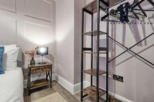 um quarto com uma prateleira de livros pretos ao lado de uma cama em Urban Lux - Modern One-Bedroom Flat in Southend-On-Sea - Southend Stays em Southend-on-Sea