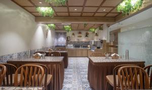 a restaurant with tables and chairs and a kitchen at Treebo Trend Urban in Surat