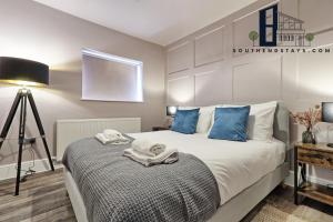 um quarto com uma cama grande e almofadas azuis em Urban Lux - Modern One-Bedroom Flat in Southend-On-Sea - Southend Stays em Southend-on-Sea