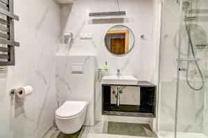 La salle de bains est pourvue de toilettes, d'un lavabo et d'une douche. dans l'établissement Panorama, à Krynica-Zdrój