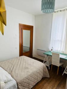 een slaapkamer met een bed, een bureau en een tafel bij Appartement - Ax les Thermes in Ax-les-Thermes
