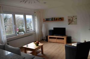 uma sala de estar com uma televisão e uma mesa em Haus Blütenzauber em Sipplingen