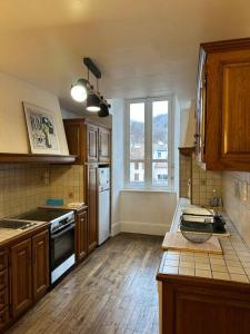 een keuken met houten kasten en een aanrecht bij Appartement - Ax les Thermes in Ax-les-Thermes