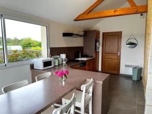 a kitchen with a counter with a table and chairs at Sweet Omaha in Colleville-sur-Mer +4 photos