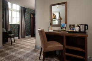 リポンにあるThe Ripon Inn - The Inn Collection Groupのデスク、椅子、鏡が備わる客室です。