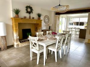 a dining room with a table and chairs and a fireplace at Sweet Omaha in Colleville-sur-Mer