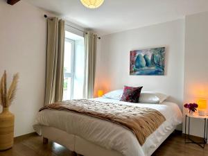 a bedroom with a large bed and a window at Sweet Omaha in Colleville-sur-Mer