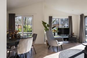 a living room with a dining room table and chairs at Vakantiepark Latour in Oirschot