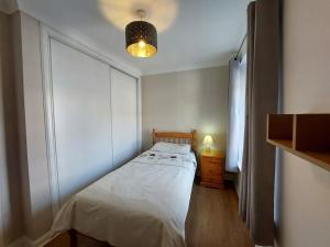 a small bedroom with a bed and a window at Swan Apartment in Earlston