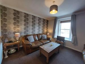 a living room with a couch and a coffee table at Swan Apartment in Earlston