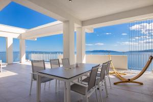een eetkamer met een tafel en stoelen op een balkon bij Penthouse Rio Kantrida in Rijeka