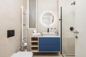 een badkamer met een wastafel, een toilet en een spiegel bij Penthouse Rio Kantrida in Rijeka