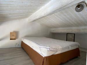 Ce lit se trouve dans un dortoir doté d'un plafond blanc. dans l'établissement Loft Sur les toits, à Aix-en-Provence