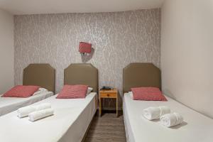 a room with two beds with red pillows at Guest House Porto Clerigus in Porto