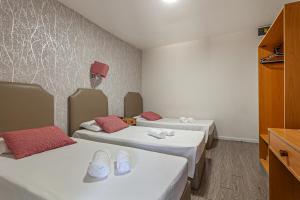a room with two beds with red pillows at Guest House Porto Clerigus in Porto