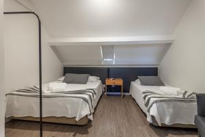 a room with two beds and a mirror at Guest House Porto Clerigus in Porto