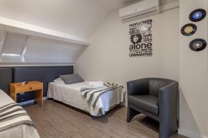 a small room with a bed and a chair at Guest House Porto Clerigus in Porto