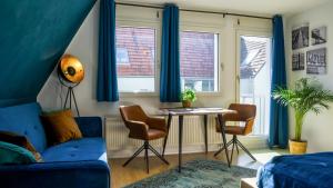 ein Wohnzimmer mit blauen Vorhängen sowie einem Tisch und Stühlen in der Unterkunft Ruhig, Zentral & Modern im Herzen Ulms in Ulm