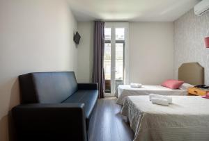 a hotel room with two beds and a couch at Guest House Porto Clerigus in Porto