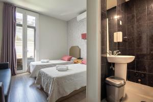 a bathroom with two beds and a sink in a room at Guest House Porto Clerigus in Porto