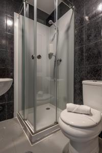 a bathroom with a shower with a toilet and a sink at Guest House Porto Clerigus in Porto