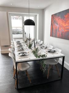 a long white table with white chairs and a black lamp at Number Nine Torquay in Torquay