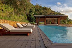 einen Pool mit Liegestühlen und ein Gebäude in der Unterkunft Pearl Beach Resort & Spa in Koh Rong Sanloem